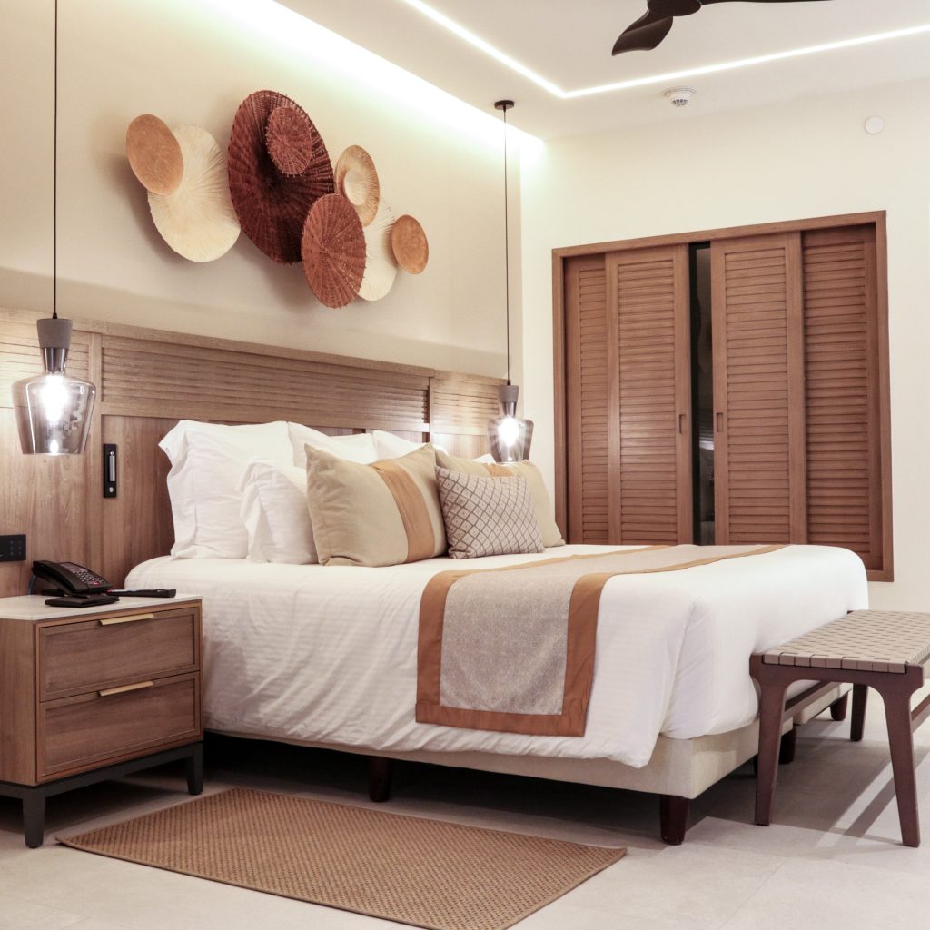 Mostrar la elegancia y calidad de la ropa de cama decorativa utilizada en hoteles, destacando cómo los textiles contribuyen a crear una experiencia de confort y lujo para el huésped.